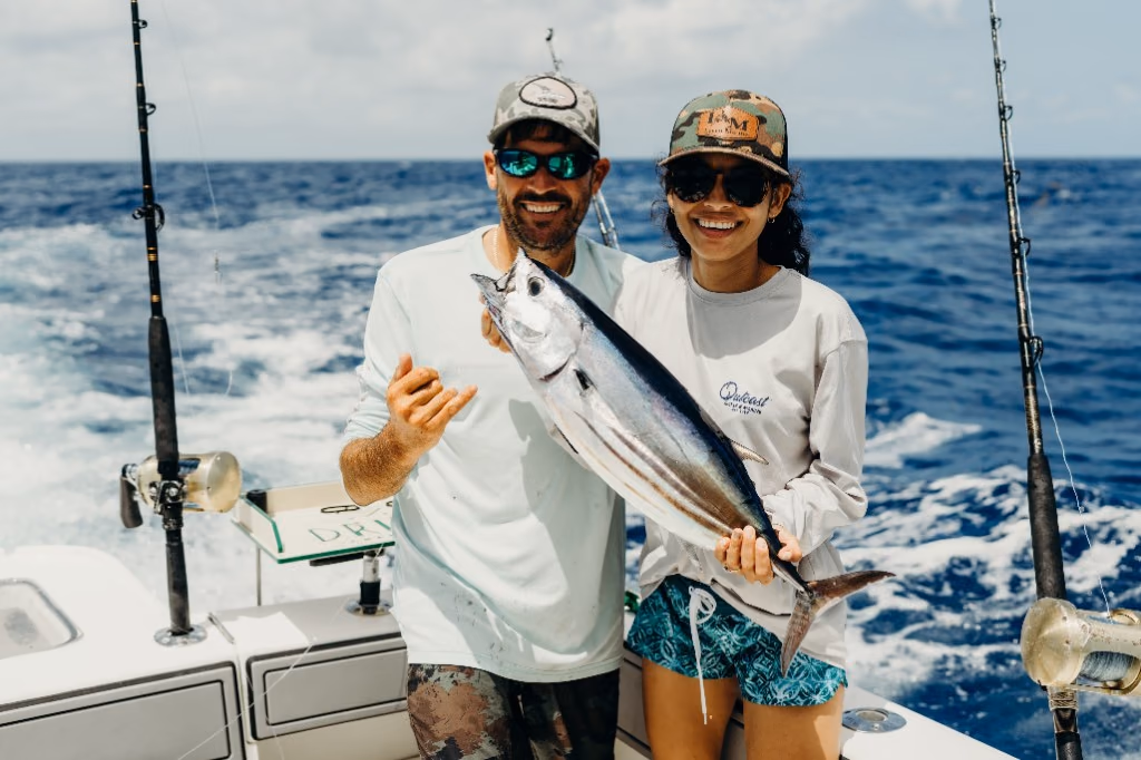 Two anglers holding a skipjack tuna caught on a Drift Charters trip