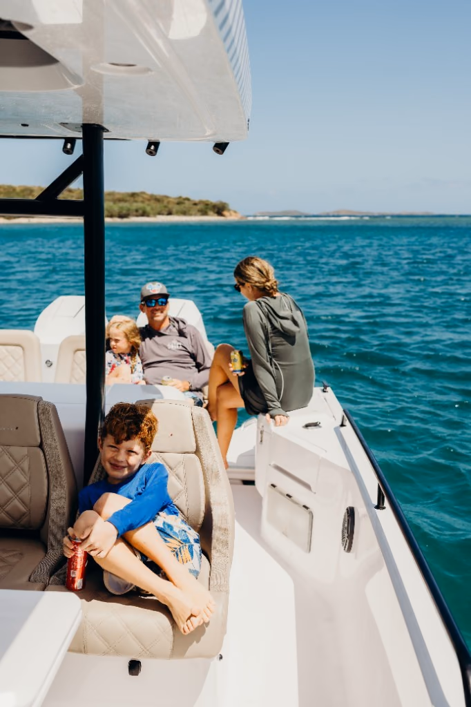 Boy relaxing in a captain's chair aboard Her Deal with his family at the bow