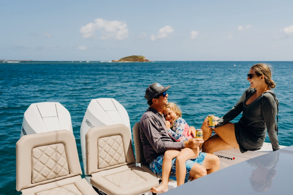 Family relaxing at the stern of Her Deal between its twin Mercury outboards